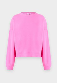 Jasnoróżowy sweatshirt z okrągłym dekoltem, długimi rękawami, ściągaczami na mankietach i lekko skróconym dołem na jasnoszarym tle.