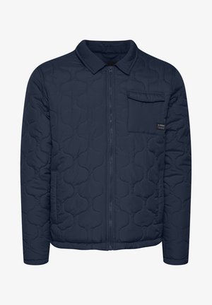 Laikattu tummansininen takki, jossa on vetoketju etupuolella, kauluksellinen kaula-aukko ja yksi rintatasku. Takki on sileäpintainen ja siinä on moderni, virtaviivainen muotoilu.