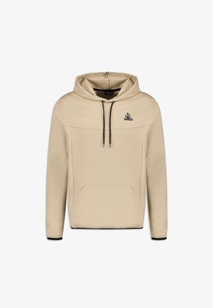 Beige hoodie gemaakt van zachte stof met zwarte koorden, voorzak met kangoeroe-pocket en een klein logo op de borst.