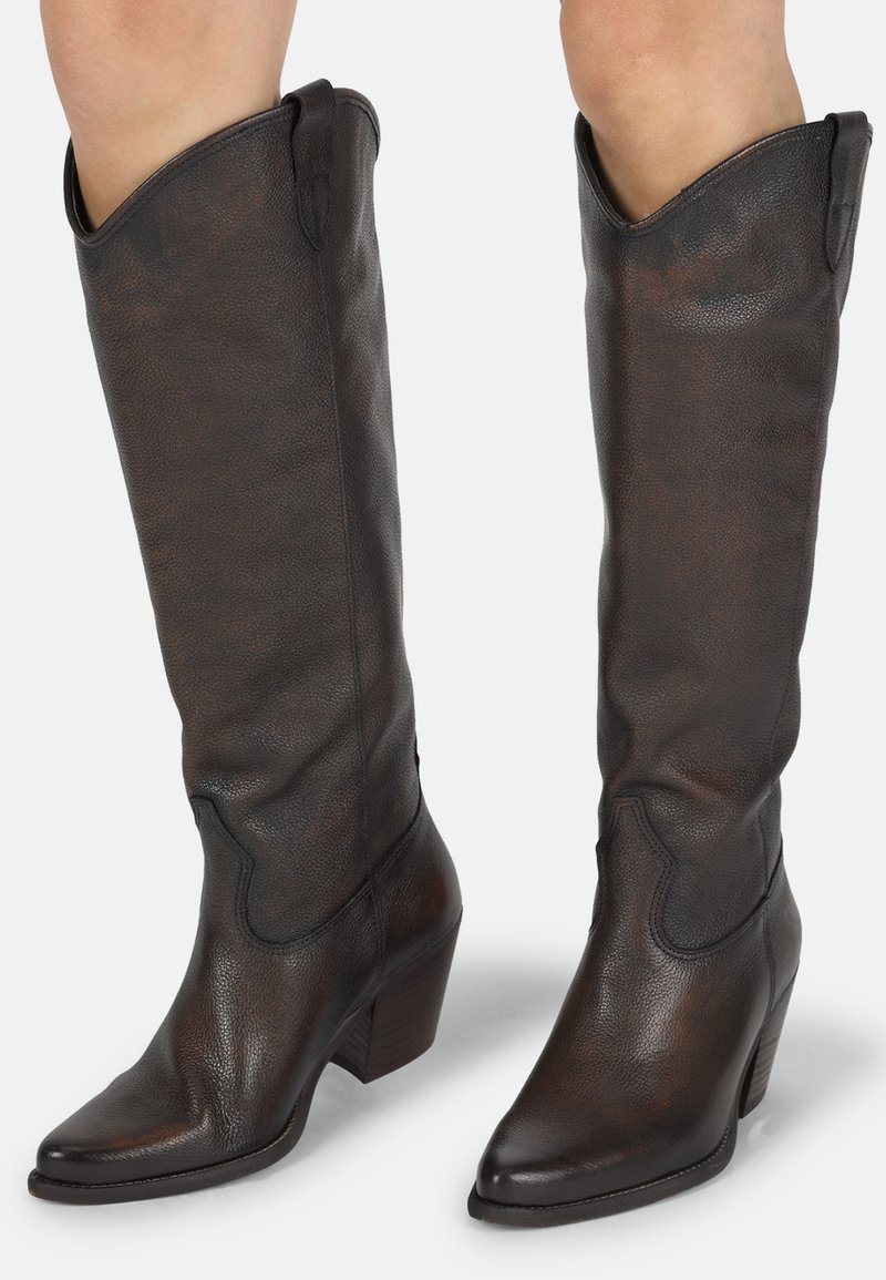 Bottes en cuir marron arrivant au genou avec une finition texturée, un bout pointu et un talon empilé. Caractéristiques de coutures décoratives le long des côtés.