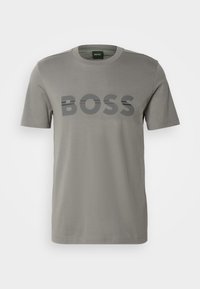 T-shirt gris clair à manches courtes avec texte noir "BOSS" centré sur la poitrine et col rond.