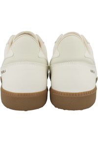 Vita sneakers med en slät läderöverdel, rund tå och en texturerad brun gummisula. Har minimal märkning på hälen.