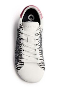 Zapatilla blanca con punta redonda, con rayas de cebra en blanco y negro y costados brillantes plateados. Diseño con cordones. Logo de Gioseppo en el interior.