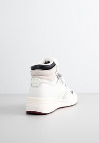 Witte sneakers met hoog ontwerp, gemaakt van suede en leer, met grijze accenten, rubberen zool en een merkpatch op de achterkant.