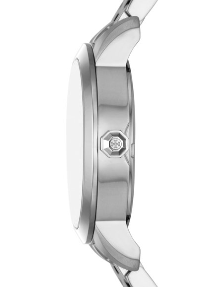 Rund silverfärgad klocka med ett polerat metallfodral, slät bezel och en hexagonal krondetalj. Har en enkel, ren design.