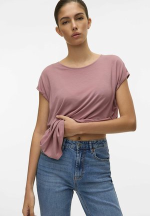 Helles Pink, kurzärmeliges T-Shirt, lockere Passform, kombiniert mit blauen High-Waist-Jeans, glatter Stoff mit dezentem Fall.