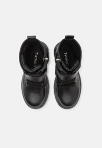 Sorte lær ankle boots med avrundet tå, polstret krage og dekorative glidelåser. Har teksturerte detaljer og en flat gummisåle.