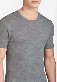 T-shirt grigio a maniche corte realizzato in un tessuto morbido e testurizzato, con scollatura rotonda e un design aderente. Nessun logo o motivo visibile.