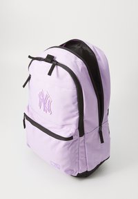 Purple backpack with black accents, featuring two zippered compartments and an embroidered logo on the front. Made of durable fabric.