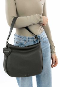 Dark gray leather handbag with textured surface, curved shape, and silver hardware. Features a heart-shaped charm with branding.