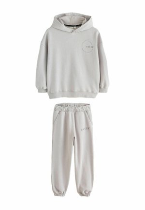 Hellgraues Kapuzensweatshirt und passende Jogginghose mit elastischem Bund, beide mit „BAKER“-Schriftzug auf Brust und Oberschenkel.