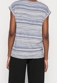 Top de manga corta a rayas en azul y blanco, fabricado con un tejido ligero. Presenta un cuello redondo y un ajuste relajado en la parte posterior.
