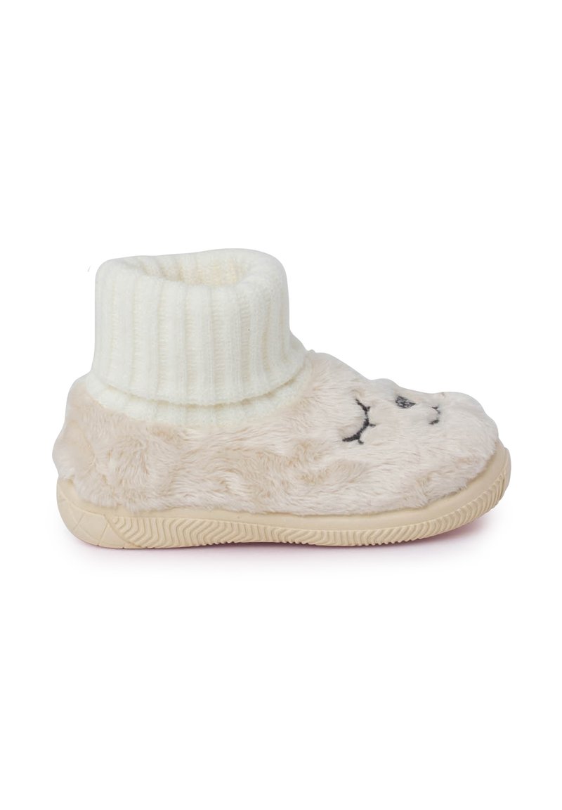 Pantofole beige morbide con un polsino bianco a coste, caratterizzate da un design di faccia ricamato e una suola in gomma testurizzata per una buona aderenza.