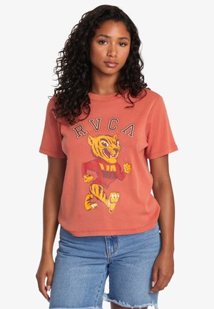 Short-sleeved orange t-shirt featuring a cartoon tiger design with "RVCA" text above. Soft fabric, relaxed fit, and crew neckline.