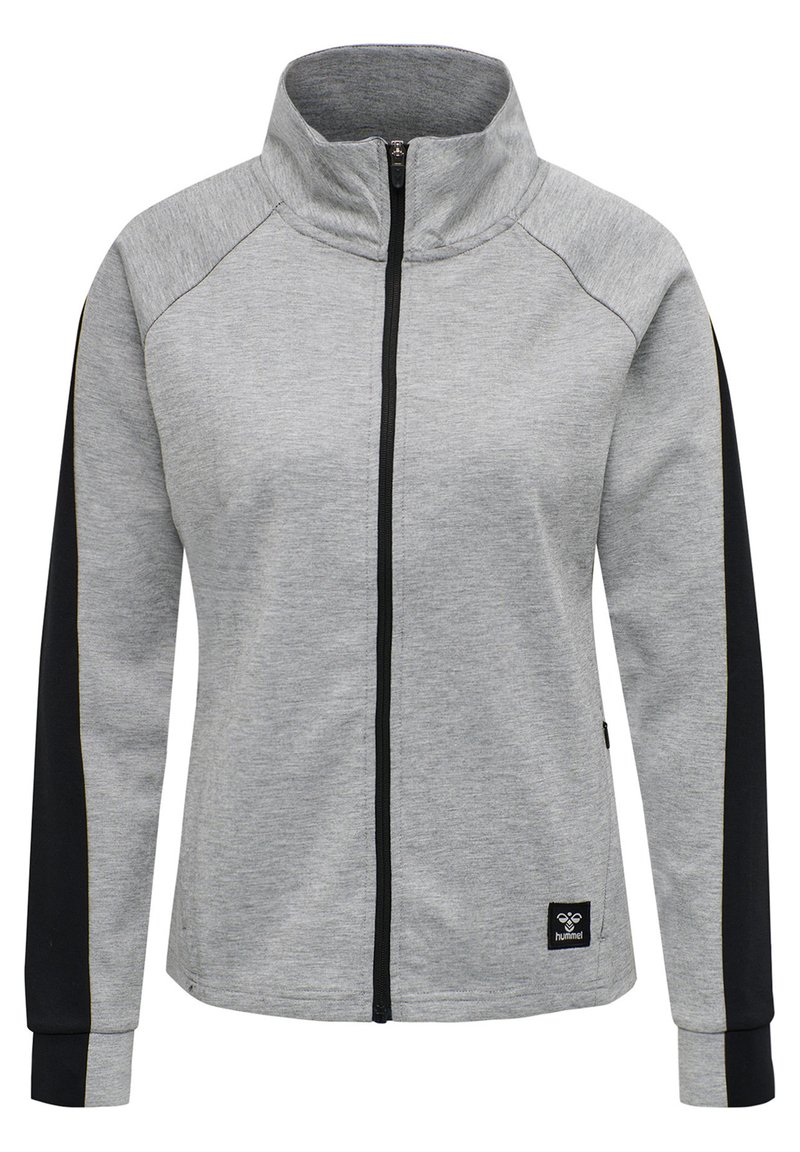 Szara kurtka zapinana na zamek z wysokim kołnierzem, czarnymi rękawami. Posiada ściągacze przy mankietach i u dołu, miękką teksturę oraz naszywkę z logo na dolnym brzegu.