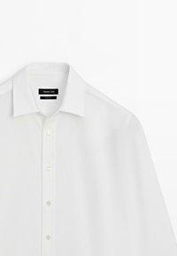 Camicia bianca con bottoni, colletto classico, realizzata in tessuto liscio, con un'etichetta "Massimo Dutti" e sei bottoni frontali.