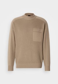 Beige knitted sweater with long sleeves, ribbed collar and cuffs, and a patch pocket on the left chest.