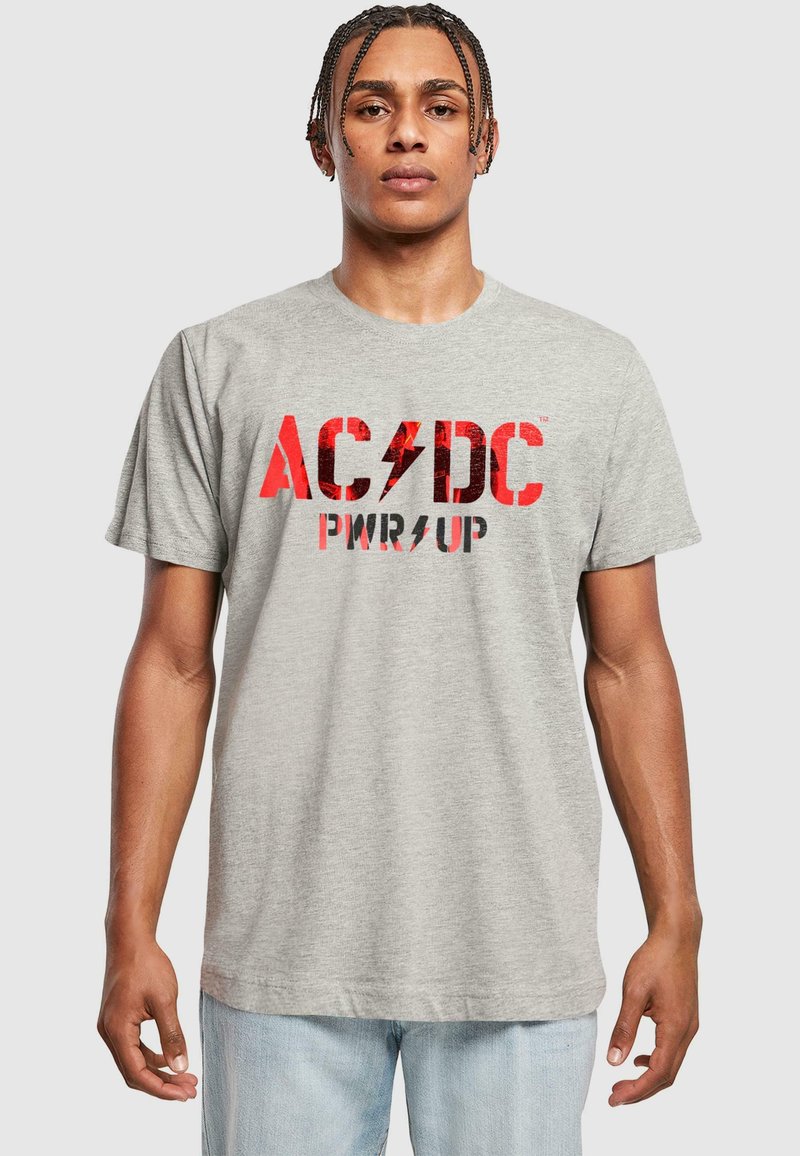 Graues Baumwoll-T-Shirt mit rotem AC/DC-Text und Blitzgrafik. Kurze Ärmel und Rundhalsausschnitt. Schlichte, lässige Passform.