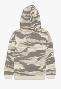 Felpa con cappuccio grigia e beige camouflage realizzata in tessuto morbido; presenta un cappuccio, maniche lunghe e polsini a coste. Motivo a onde sottile su tutta la superficie.
