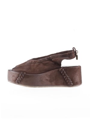 Brązowy sandał na koturnie z zamszu z odkrytymi palcami, otwartą piętą i zamkiem błyskawicznym na białym tle.