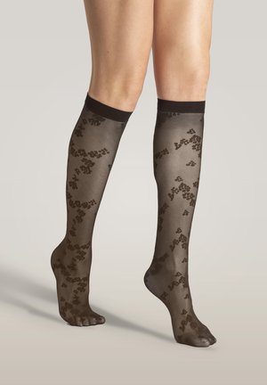 Durchsichtige schwarze, knielange Socken mit floralem Spitzenmuster, abgeschlossen mit einem soliden schwarzen Band oben, das das zarte, strukturierte Design hervorhebt.