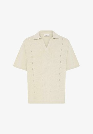 Κρεμ πλεκτό πόλο μπλουζάκι με κοντά μανίκια, ανοιχτή V-λαιμόκοψη και διακριτικά κάθετα δαντελένια σχέδια, κατασκευασμένο από ελαφρύ υφασμένο ύφασμα.