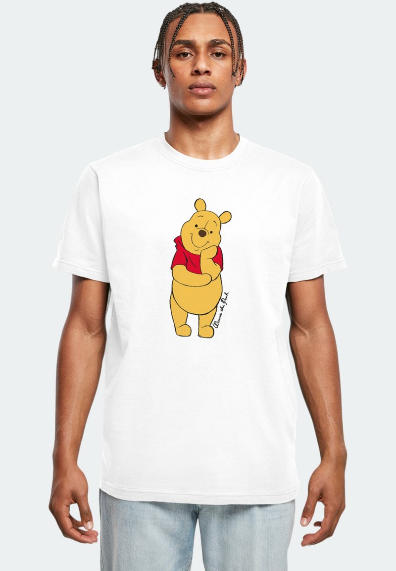 Weißes Baumwoll-T-Shirt mit einem grafischen Motiv eines lächelnden gelben Bären in einem roten Shirt, der mit einer Hand auf seinem Kinn steht.