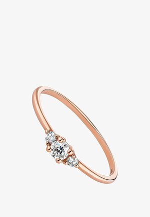 Anillo de oro rosa con una banda lisa y un diamante redondo central flanqueado por dos diamantes redondos más pequeños, todo en un diseño minimalista.