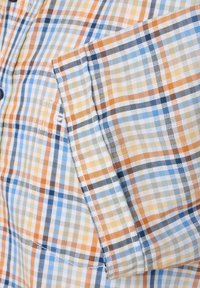 Kurzarm-Hemd aus Karostoff aus Baumwolle, in den Farben Pfirsich, Blau und Beige, mit einer Brusttasche und einer glatten Textur.