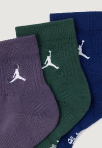 Kolm paari meeste sokke lilla, rohelises ja tumesinises värvuses. Igal paaril on valge Air Jordani logo ja ribakujundusega ülemine osa.
