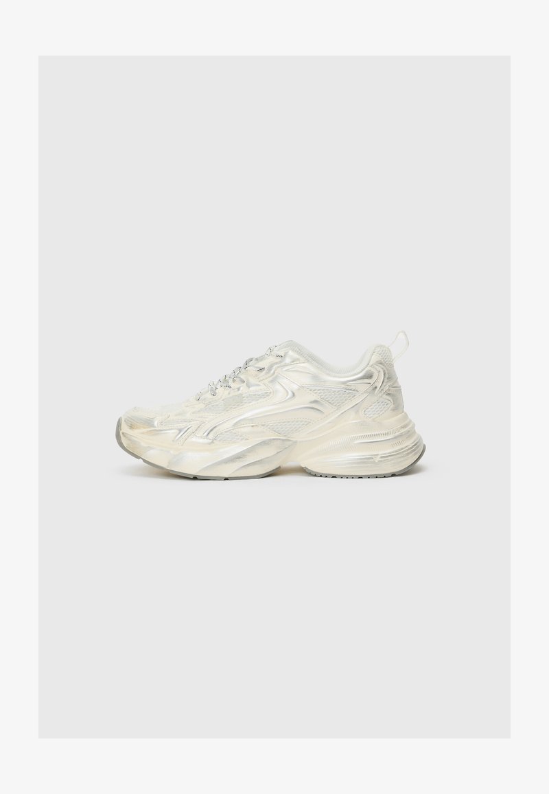 Λευκό αθλητικό παπούτσι με γυαλιστερή, υφασματική επιφάνεια. Διαθέτει λεπτομέρειες από διχτυωτό ύφασμα, χοντρή σόλα και ανακλαστικά στοιχεία. Οι κορδόνες είναι σε ασημί απόχρωση.