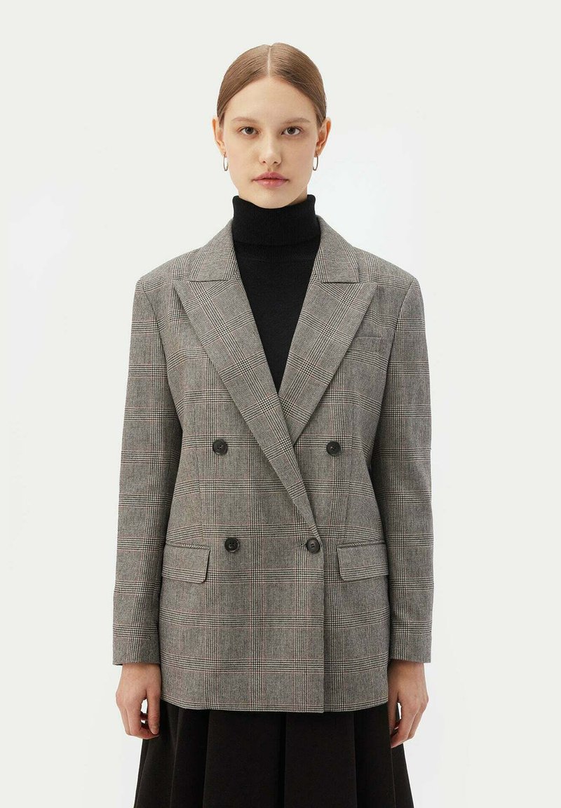 Grå rutig dubbelknäppt blazer med stora kragar, två framfickor och svarta knappar. Texturerat tyg med en strukturerad passform.