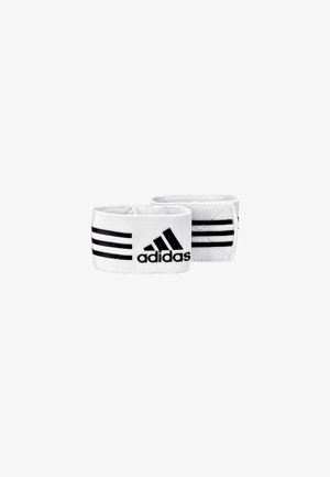 Para białych elastycznych opasek na nadgarstek Adidas z czarnymi trzema paskami i logo Adidas na jednolitym białym tle.