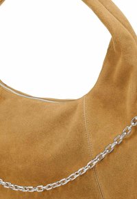 Wildlederhandtasche in hellbraun mit geschwungenem Design, versehen mit einer silbernen Kettenakzent und einem Reißverschluss oben zum Schließen.