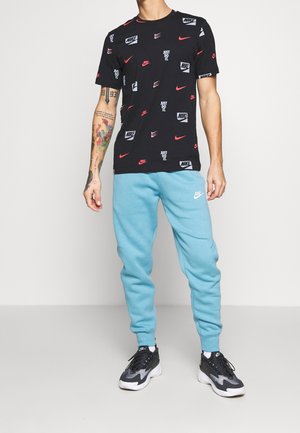 Black t-shirt with multicolored Nike logos and text, paired with light blue sweatpants. Both are made of soft, breathable fabric.