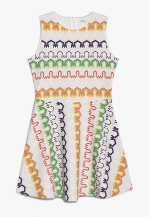 Vestido blanco sin mangas con cintura ajustada y bordado en zigzag de colores en franjas naranja, verde, morado y rojo a lo largo de la tela.