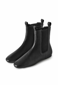 Botas de tobillo de cuero negro con paneles laterales elásticos, punteras redondeadas y tabulaciones en el eje. Textura suave con detalles mínimos.