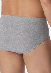 Slip in cotone grigio con una texture liscia, vita elastica e un taglio classico. Il tessuto presenta una leggera trama mélange.