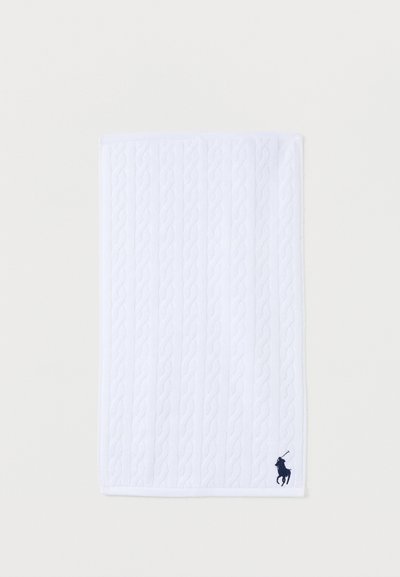 Λευκή ορθογώνια πετσέτα με κάθετη υφή πλεκτού καναλιού και κέντημα λογότυπου παίκτη πόλο σε σκούρο μπλε χρώμα στο κάτω δεξί μέρος.
