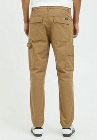 Beige cargo pants with a straight cut, featuring two back pockets, side cargo pockets, and durable fabric with a smooth texture.
