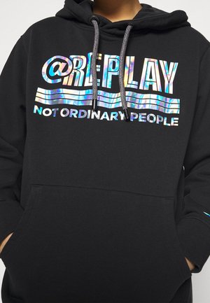 Sweat à capuche noir avec texte holographique "@REPLAY" et "NOT ORDINARY PEOPLE" sur le devant, doté de cordons de serrage et d'une poche kangourou frontale.
