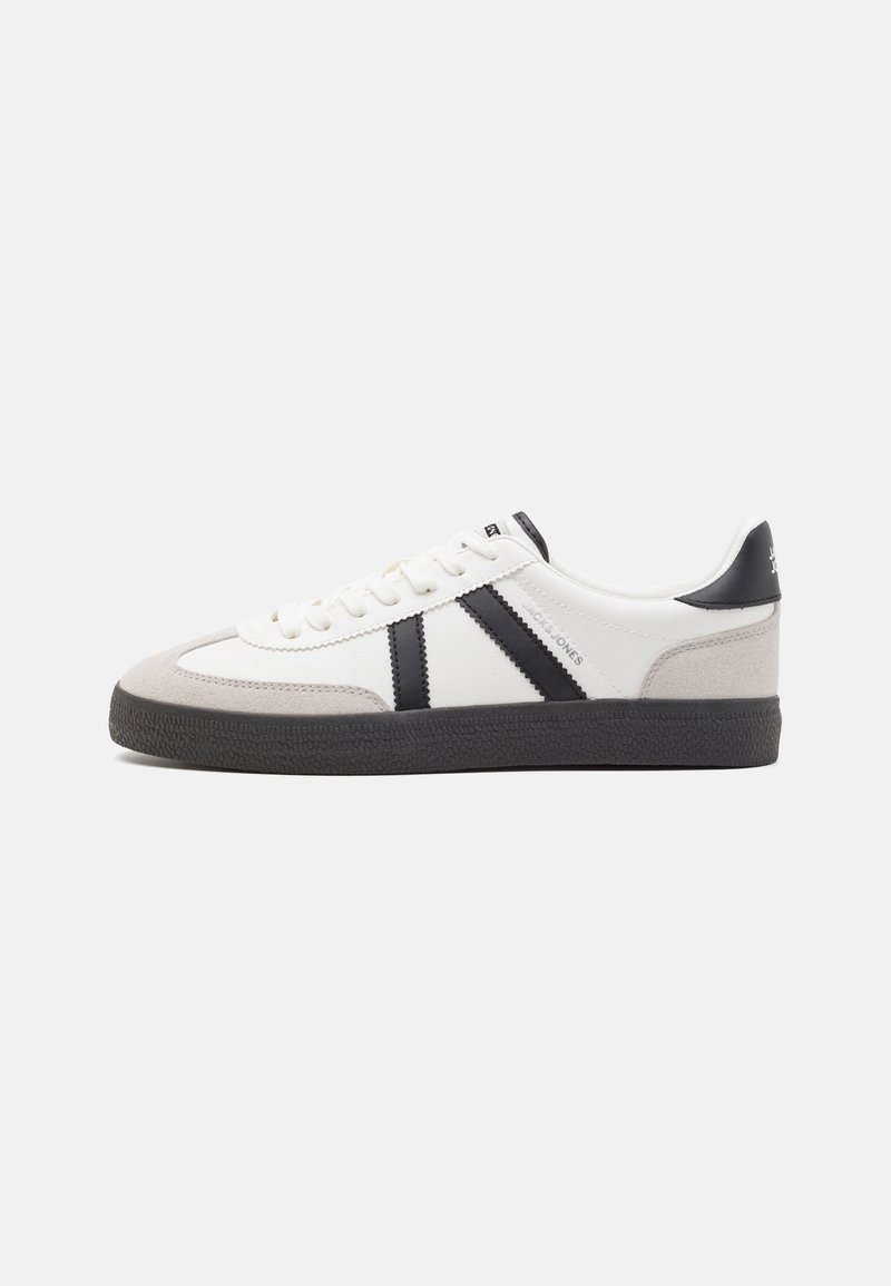 Sneaker bianco con accenti neri e grigi, dotata di una punta grigia testurizzata, suola in gomma nera e lacci bianchi piatti. Design pulito, stile minimalista.