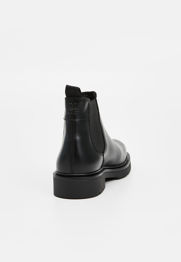 Bottines Chelsea en cuir noir avec panneaux élastiques sur les côtés, bout arrondi, semelle robuste et détail de logo embossé sur la languette du talon.