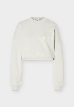 Krótkia bluza w kolorze ecru z długimi rękawami oraz ściągaczami przy mankietach i dekolcie, zaprojektowana do noszenia na co dzień.