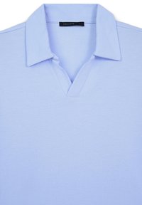 Polo bleu clair avec un col évasé et une étiquette noire à l'intérieur du cou portant la mention "CALLIOPE L."