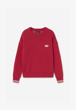 Punane kootud ümarhoolseelne kampsun väikese valge "kaotiko society" logoga rinnal ja valgete triipudega soonikkoes mansettidega.