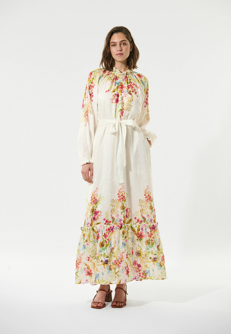 Weißes Maxikleid mit langen Ärmeln, fransigem Saum und Bindegürtel. Mit leuchtenden rosa und gelben Blumen auf einem strukturierten Stoff.