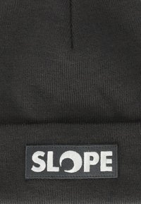 Svart stickad mössa med uppvikt design. Har en rektangulär patch med ordet "SLOPE" i vit brodyr. Mjuk textur.