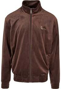 Brun zip-up jakke laget av myk, teksturert stoff. Har høy krage, elastiske mansjetter, og en liten brodert logo på brystet.