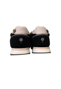Sneaker con una struttura in suede nero, accenti grigio chiaro e un tallone in pelle beige. Presentano un logo ad albero e un bottone di legno rotondo sul retro.